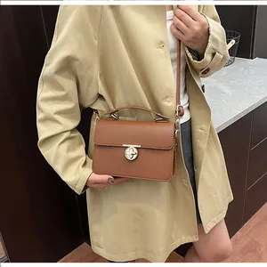 Détail du sac à main marron en cuir grainé avec fermoir rotatif en métal doré chic