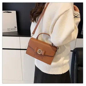 Vue détaillée du sac à main en cuir marron avec texture litchi et nœud décoratif