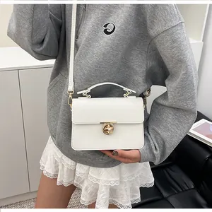 Détails du sac blanc en cuir à motif litchi avec fermoir doré et bandoulière fine