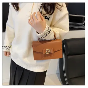 Détails du sac à main en cuir marron avec nœud et fermoir pivotant en métal doré