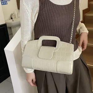 Bolso tote beige con textura de cocodrilo, cadena dorada y asa de recorte chic
