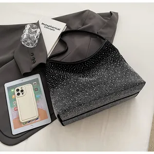 Vista detallada del bolso negro con densos diamantes de imitación plateados y asa de cuero