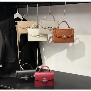 Détail de sacs en cuir texturé litchi avec un fermoir rotatif métallique rond et élégant