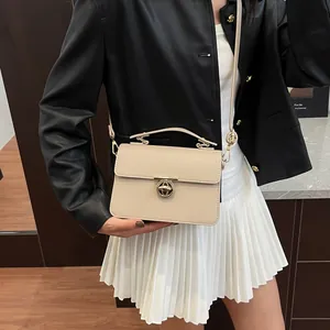 Sac à main beige en cuir grainé avec fermoir rotatif doré et bandoulière amovible