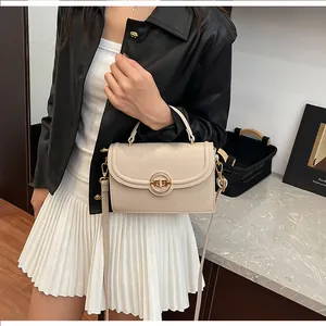 Vue détaillée du sac en cuir grainé litchi avec fermoir rotatif doré et bandoulière