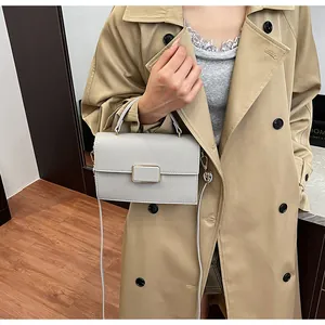 Détail du sac à main en cuir beige avec boucle métallique dorée et bandoulière réglable
