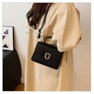 Détail du sac à main en cuir grainé noir avec boucle métallique en U dorée élégante