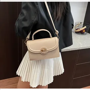 Détails du sac en cuir grainé beige avec fermoir rotatif doré et texture lychee
