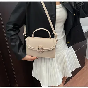 Détail du sac à main beige texture litchi avec boucle anneau en métal et finitions dorées