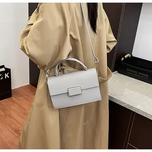 Détail du sac à main en cuir bleu clair avec motif litchi et boucle en métal doré