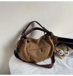 Primer plano de bolso tote de lona vintage con asas de cuero y correa ancha
