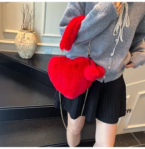 Detail der roten Herz-Plüschtasche mit goldener Kette und süßen Bommel-Anhängern