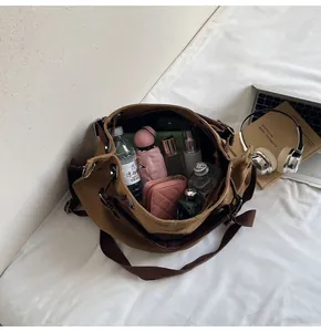 Bolso tote de lona marrón que muestra capacidad con botella de agua y objetos diarios