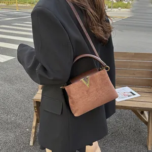 Bolso vintage de ante en color caramelo y marrón con una hebilla en V dorada