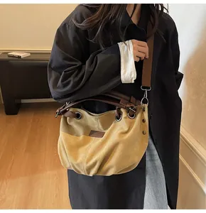 Vista detallada del bolso tote de lona vintage que muestra la tela y el logo de cuero