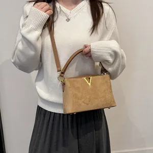 Bolso de ante sintético marrón con logo V dorado lucido con un elegante conjunto otoñal
