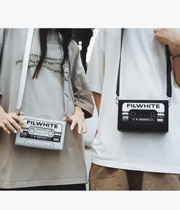 Primer plano de bolsos bandolera retro con forma de casete en negro y plateado con logo