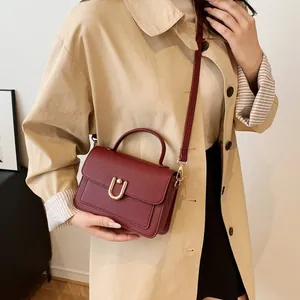 Sac à main bordeaux en cuir grainé avec boucle dorée en U et bandoulière amovible