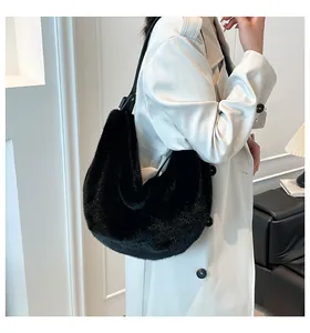 Détail du sac hobo en fausse fourrure noire avec bandoulière en cuir sur mannequin