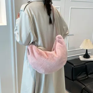 Sac bandoulière demi-lune en peluche rose porté par un mannequin, grand format