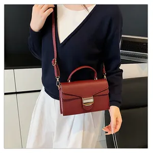 Détails du sac en cuir grainé bordeaux avec bandoulière réglable et fermoir doré chic