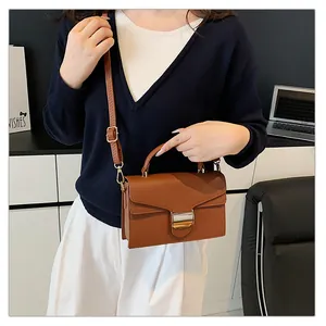 Détail du sac à main marron en cuir grainé avec boucle métallique et bandoulière réglable