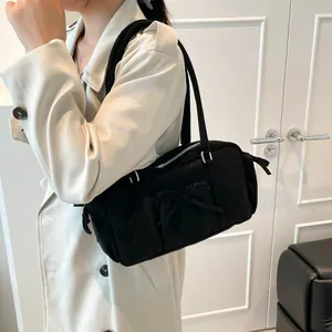 Bolso de hombro minimalista de tela negra con lazo decorativo y cremallera plateada