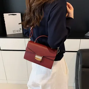 Sac à main bordeaux chic avec texture litchi, boucle dorée et bandoulière réglable