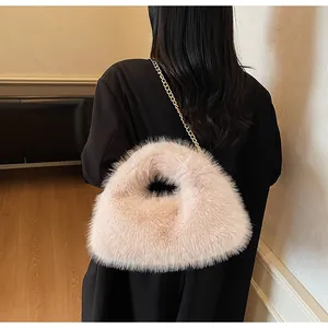 Détail du sac à main en peluche avec une bandoulière chaîne dorée porté à l'épaule