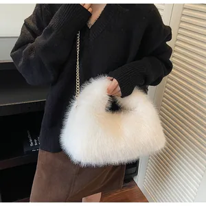 Détail du sac à main blanc en fausse fourrure avec chaîne dorée porté par un mannequin chic