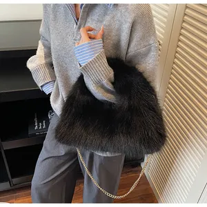 Détail du sac à main noir en fausse fourrure avec bandoulière chaîne dorée sur modèle