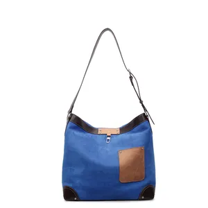 Blue suede tote bag with brown leather trim and front pocket for casual commute