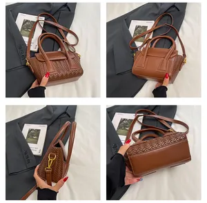 Detalle de bolso marrón vintage con textura tejida y correa de hombro ajustable
