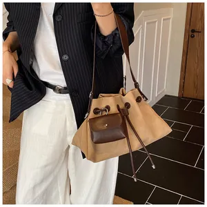 Dettaglio della grande borsa a secchiello opaca con tracolla in pelle e mini astuccio