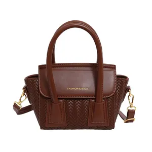 Bolso de mano marrón con textura trenzada, asas y correa de hombro desmontable estilo 2025