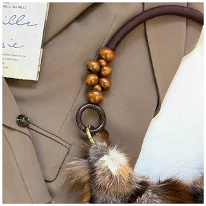 Macro detail of a vintage underarm bag showing wooden beads and brown fur texture