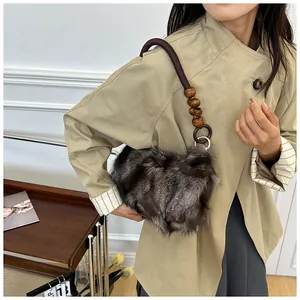 Detailed close-up of dark brown plush fur bag with woven rope handle and wooden beads