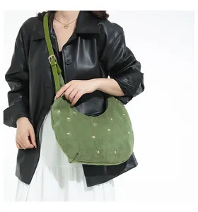Détail du sac hobo vert avec clous dorés et bandoulière réglable sur modèle