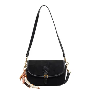 Matte black crossbody bag with vintage gold buckle and stylish bead charm detail