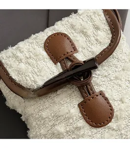 Close-up of the vintage horn buckle and tweed fabric detail on this chic crossbody bag