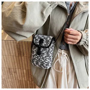 Mini crossbody phone bag in black and white tweed fabric with black leather flap detail