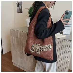 Detalle del bolso tote de punto con bordado de Mama en leopardo y textura suave