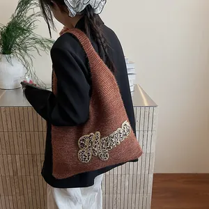 Bolso tote de punto marrón con parche de leopardo Mama llevado por una modelo