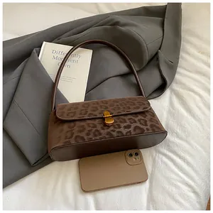 Detail der Leoparden-Achseltasche mit goldener Metallschnalle und Smartphone-Größenvergleich