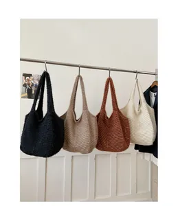 Hanging knitted tote bags showing plush texture in black, taupe, caramel and beige colors
