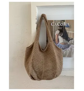 Close-up of deep brown knitted tote bag with horizontal stripes and soft fuzzy texture