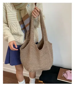Detailed close-up of warm brown chevron knit tote bag with thick wool-like texture