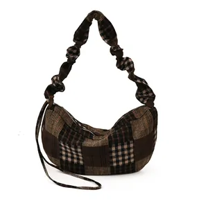 Vintage plaid half-moon crossbody bag with decorative pleated wide strap on white background