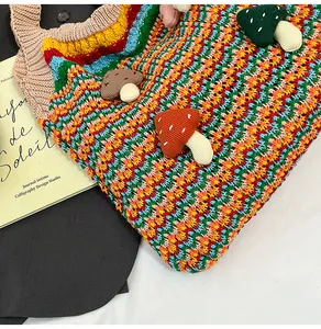 Close-up of handmade crochet tote bag featuring multi-color wavy stripes and 3D mushroom patches