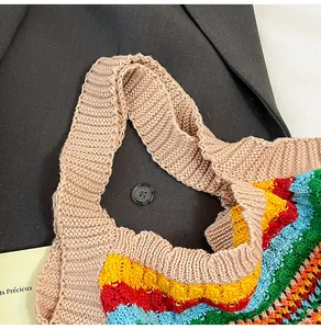 Detail of colorful knitted tote bag handles against a dark suit jacket background
